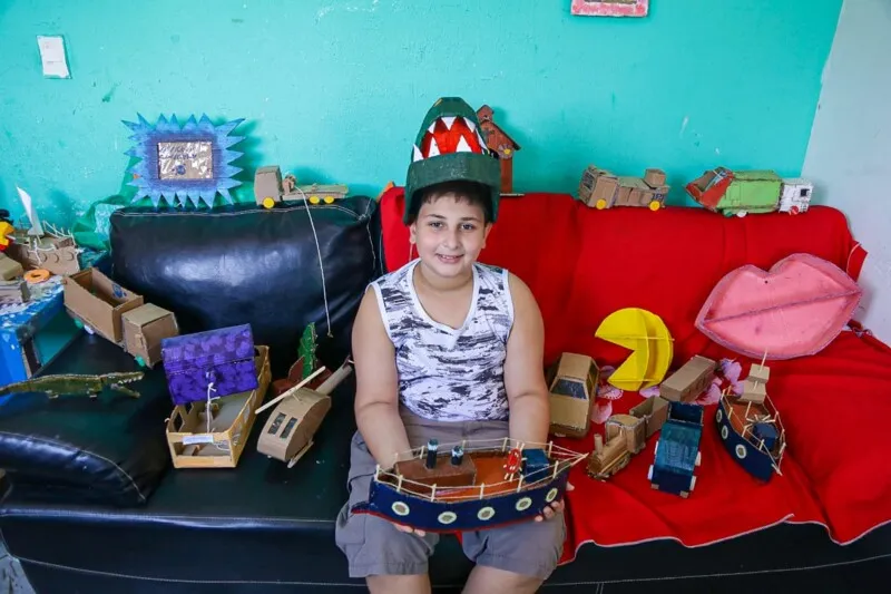O garoto tem 10 anos e se diverte fazendo itens de papelão