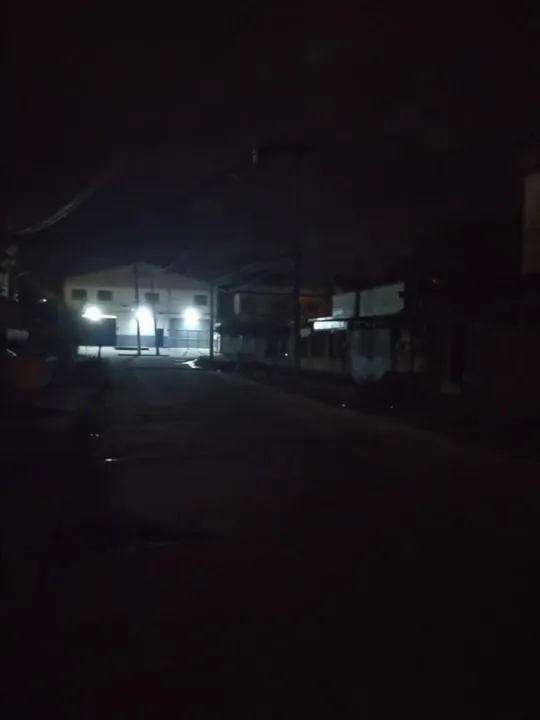 Ao final da rua, ficam luzes de um depósito que trazem um pouco de visão para o local
