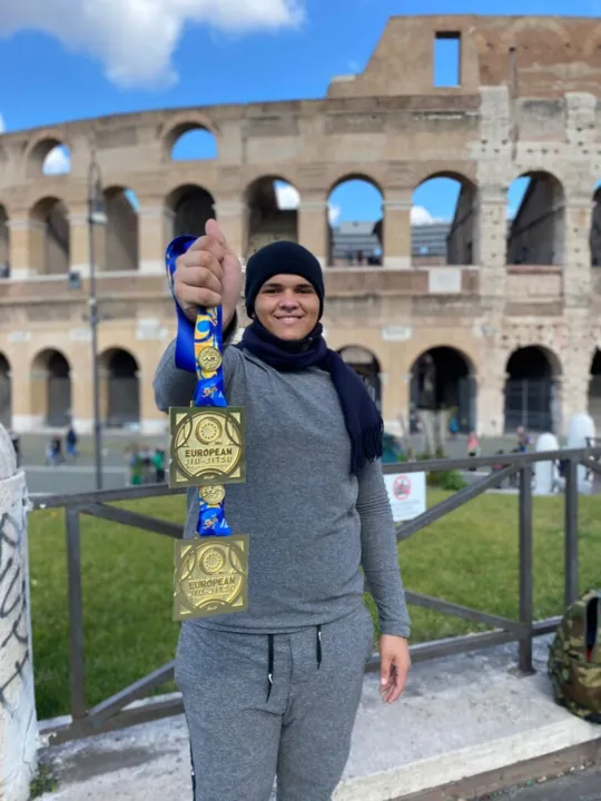 João Victor exibindo suas conquistas com o Coliseu de Roma ao fundo