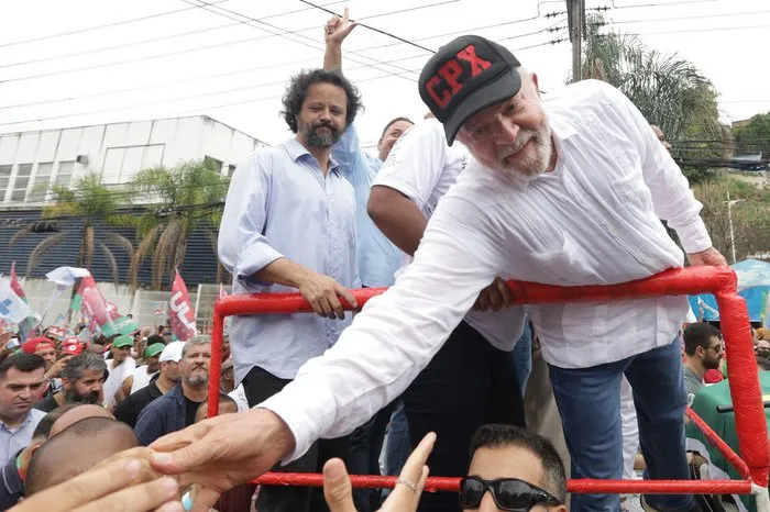 Sigla em boné do ex-presidente Lula vira alvo de embate entre eleitores na internet.