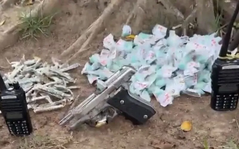 Foi feita a apreensão de uma pistola, um rádio comunicador e drogas