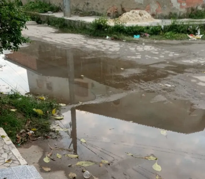 Água fica empoçada na frente da casa de morador