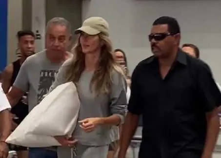 A modelo desembarcou com seu travesseiro na mão e acompanhada do seu segurança