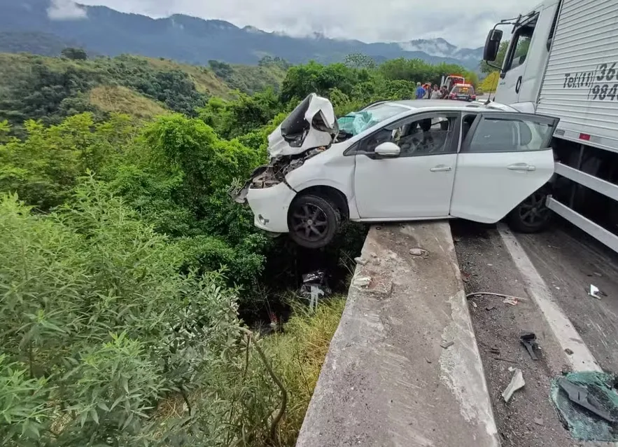 As imagens do acidente mostram que um dos carros ficou pendurado na mureta da serra