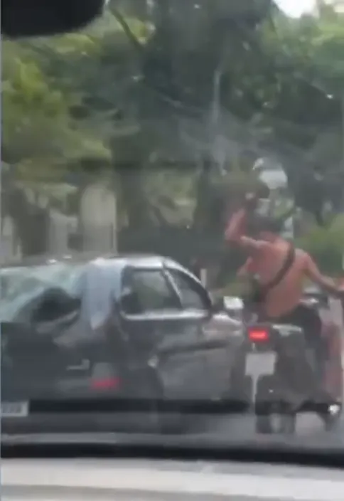Momento em que motociclista bate com capacete em carro, durante briga