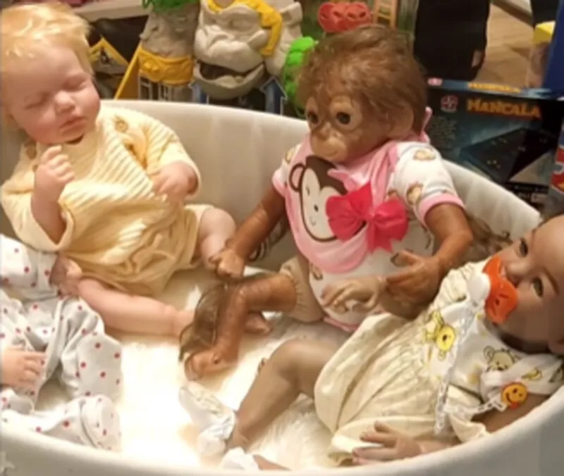 A loja colocou bonecas brancas ao lado de um macaco e uma boneca negra na vitrine