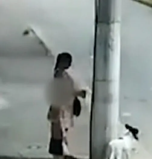 Momento em que mulher amarra cachorra em posto antes de abandoná-la