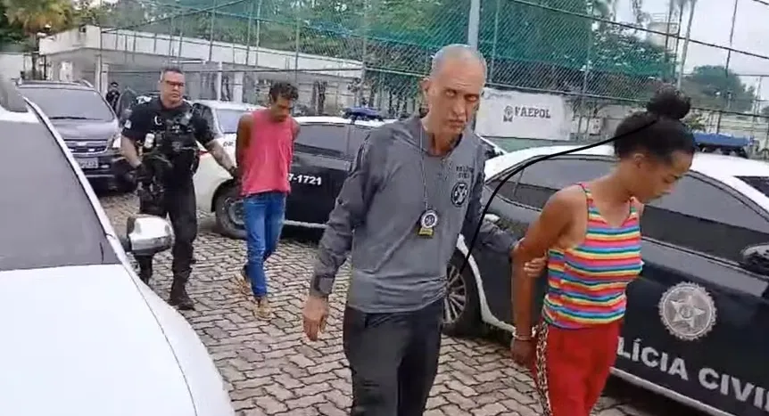 O casal ao chegar na Cidade da Polícia acompanhado por agentes