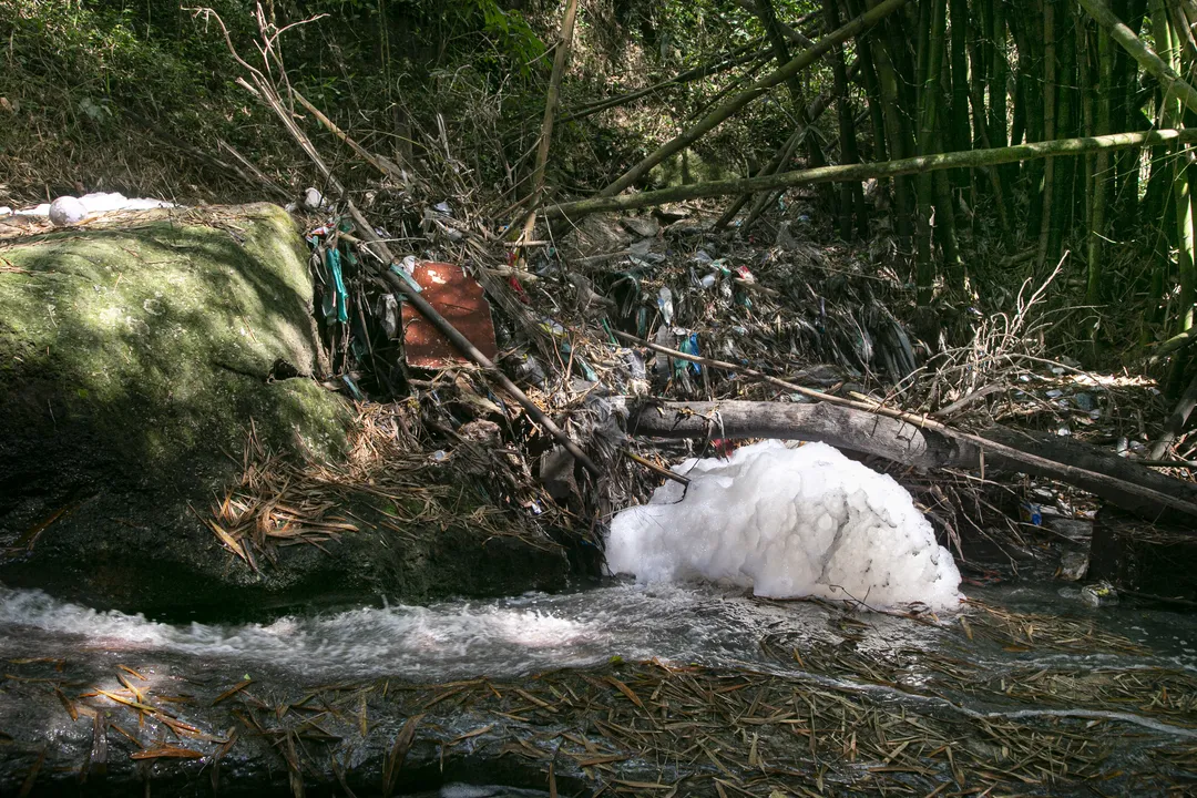 Ao longo do Rio Sapê, há diversos resíduos de lixo doméstico, restos de construções e espuma de produtos químicos em suas água