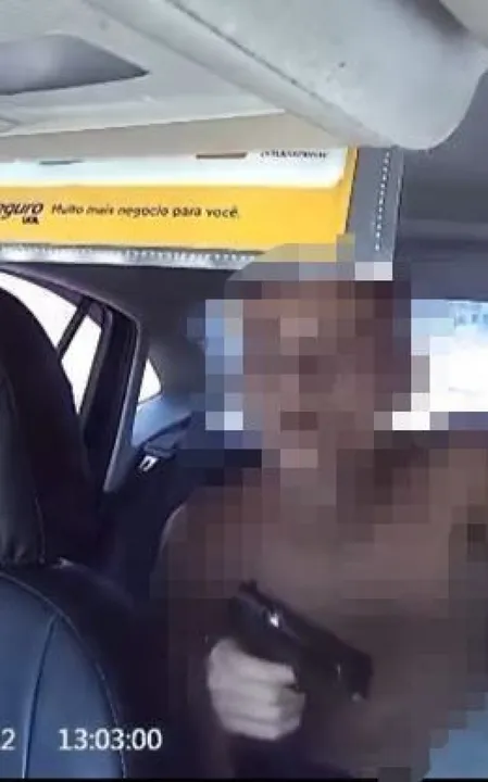 Um dos passageiros saca uma arma e ordena que a vítima desbloqueie o celular