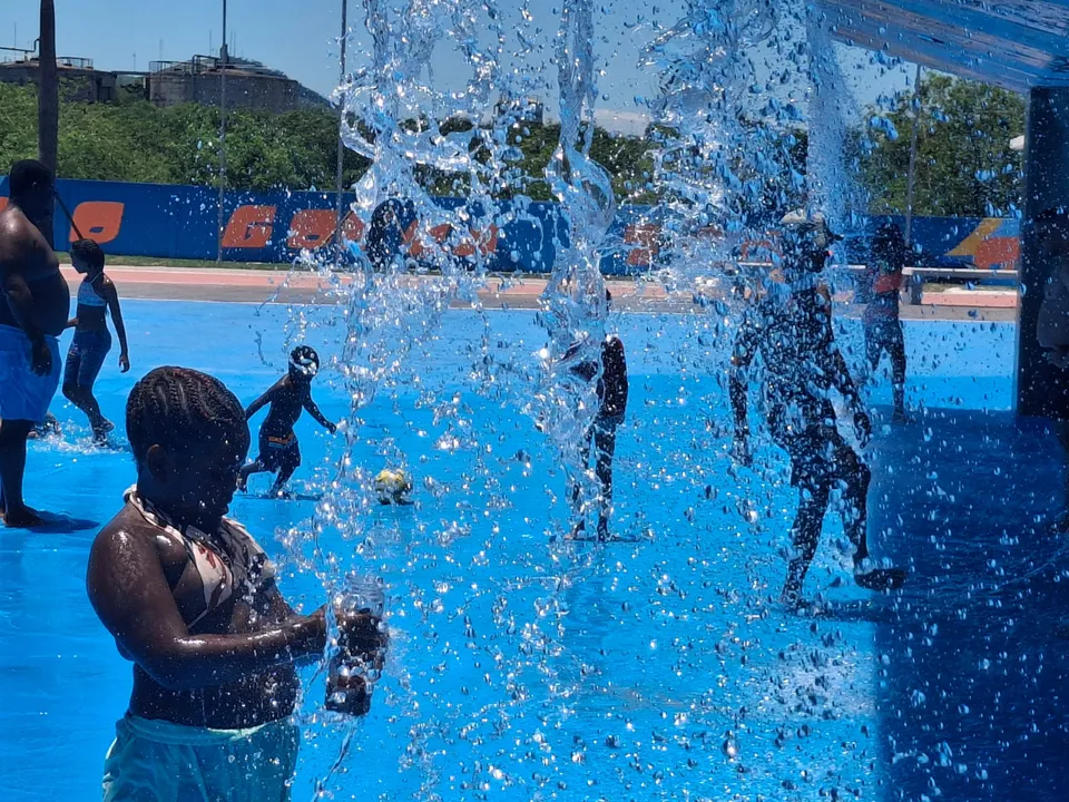 Crianças se refrescando na cascata do Parque RJ Nosso Sonho