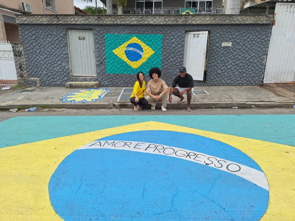 Aloan, Jefferson e um dos filhos do casal, Jean organizaram com vizinhos e familiares a tradicional pintura da rua em Copas do Mundo