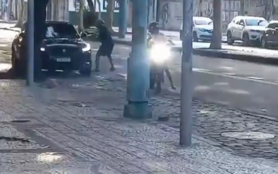 Momento em que um dos assaltantes aponta a arma contra o militar