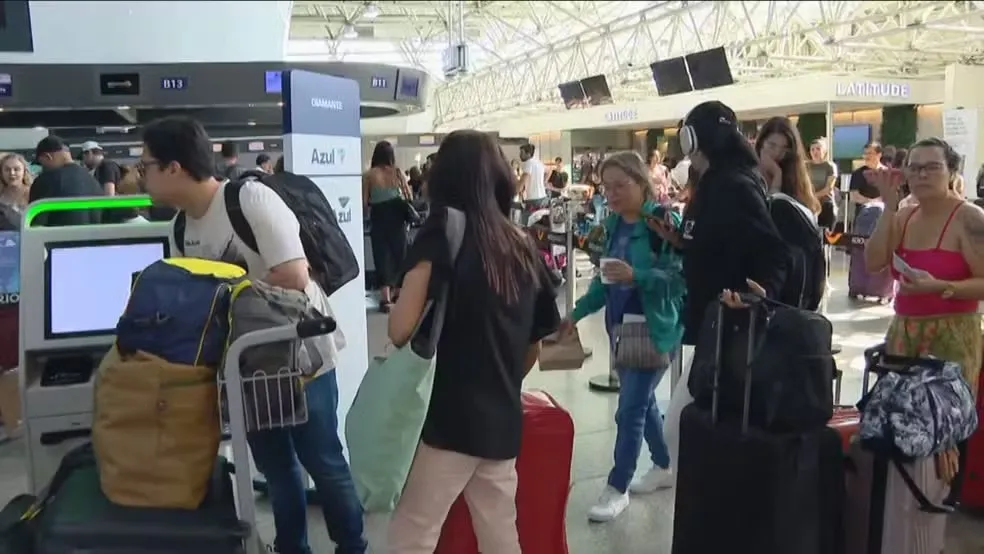 No saguão do aeroporto passageiros formam longas filas esperando para embarcar