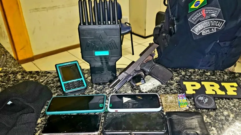 om ele foi encontrado uma arma municiada, além de diversos aparelhos celular e um dispositivo utilizado para bloquear rastreadores de veículos de carga