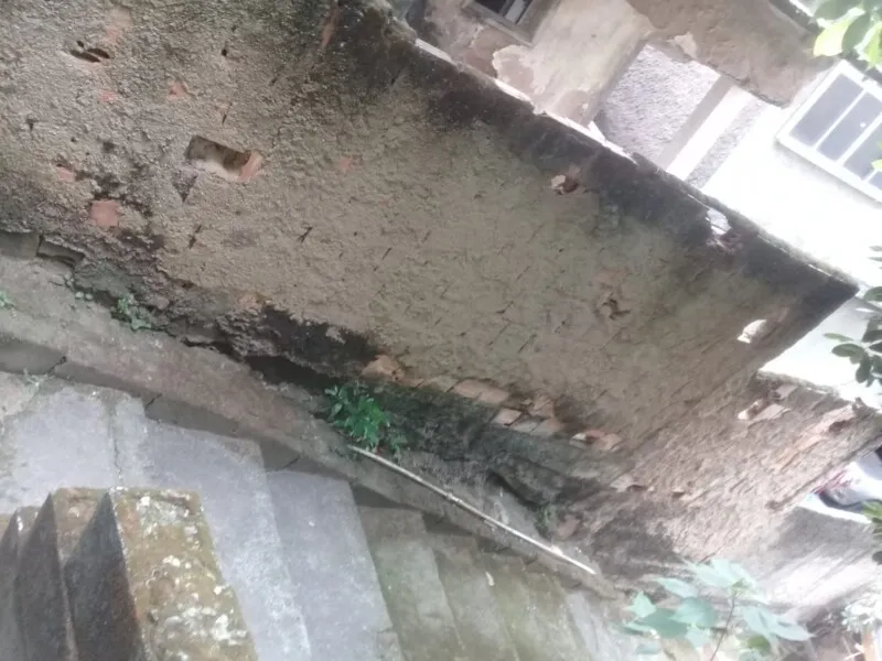 A família tem medo do muro cair a qualquer momento, pois a água escavou ele por baixo