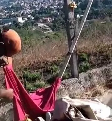 Homem, de fuzil, pôs fogo na espécie de bandeira deixada pelos criminosos do CV
