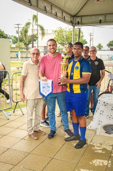 À esquerda, ex-jogador Gerson, presidente do Instituto Canhotinha de Ouro, na entrega de troféu a uma das equipes campeãs