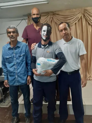 O motoboy (ao centro, com o rosto pintado) já entregou cestas básicas para 70 pessoas
