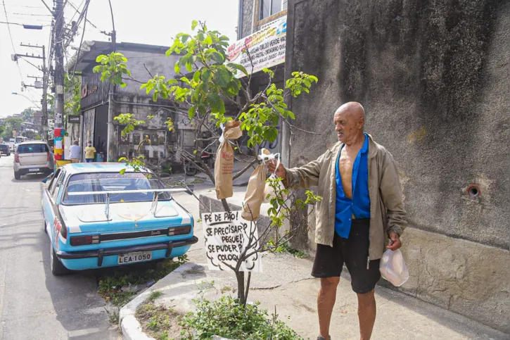 Seu sebastião  ajuda a distribuir a 'colheita'  pelo bairro 