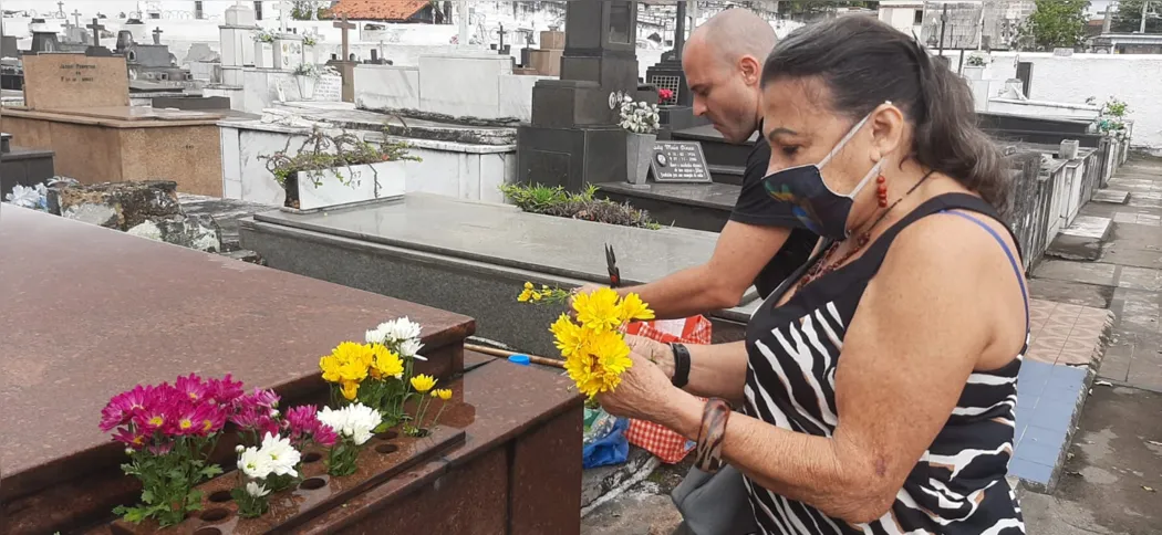 Rosely deixa flores e limpa os túmulos de seus familiares que faleceram