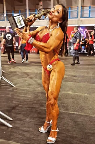 Claudia segurando seu mais recente troféu, na competição 'O Muscle Contest Mister Master da NPC (Federação Internacional)'.