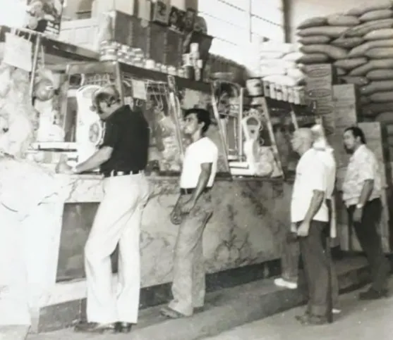 Homens enfileirados em comércio no Mercado Municipal
