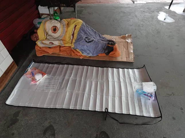 Pessoa em situação de rua dorme na manta produzida com caixas de leite
