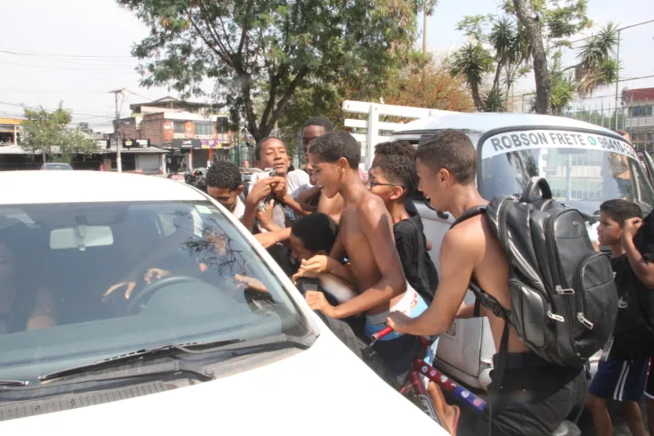 Crianças tentando pegar as sacolinhas de doces