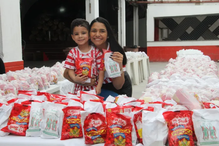 A diretora administrativa da Porto da Pedra, Francine Montibelo e seu filho durante e distribuição de doces de São Cosme e Damião