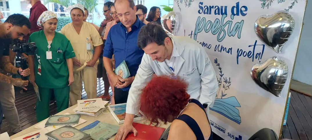 Com uma caneta dourada, a escritora e poetisa autografou, com a mão esquerda, 300 livros