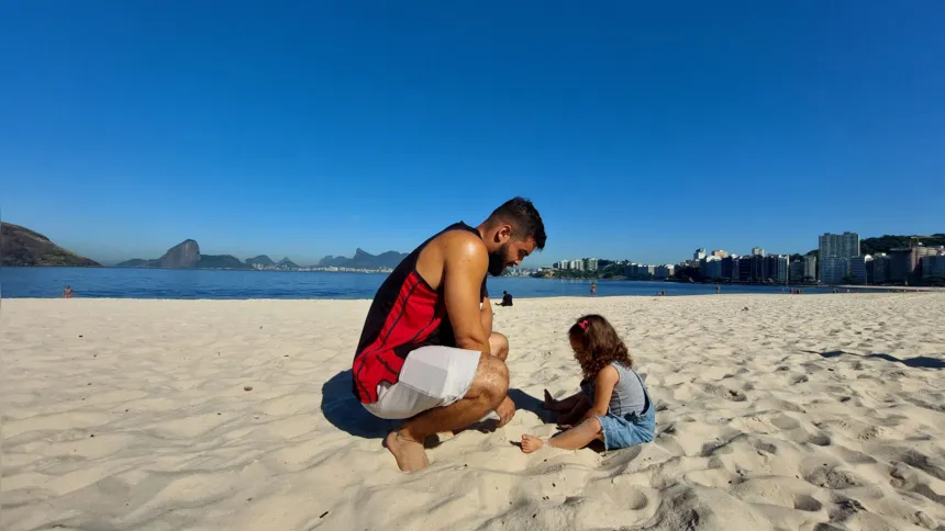 Pai e filha se divertem na areia