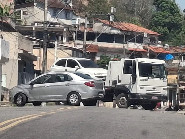 Outros dois veículos, junto ao caminhão reboque, seguem atravessados, complicando o trânsito