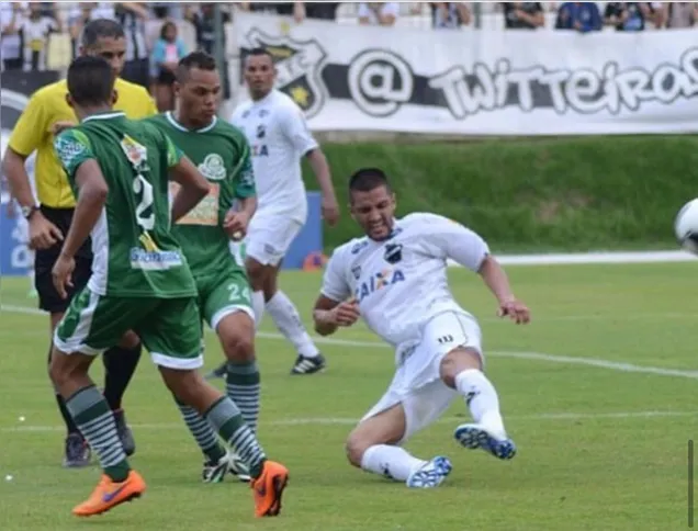 João, ao centro, em um jogo defendendo o Palmeira