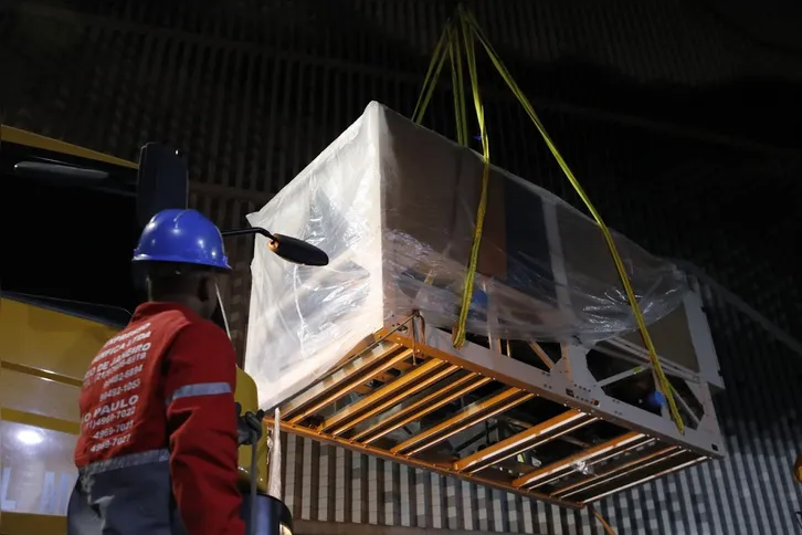 Equipamentos do sistema de climatização do MIS são içados durante operação noturna com auxílio de caminhões guindastes