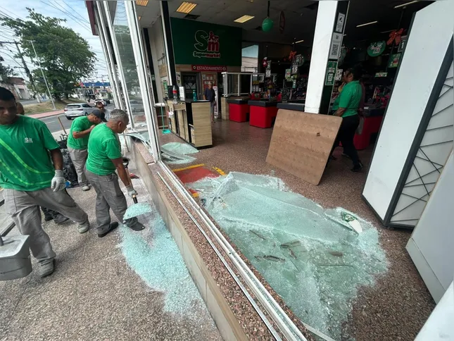 Funcionários limpam destroços após madrugada de violência no bairro