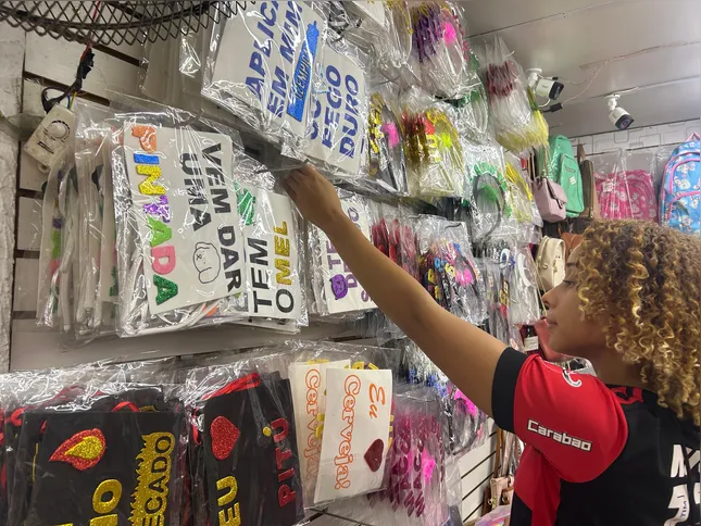 A atendente Maria Mercedes diz que as plaquinhas e as hot pants são muito procuradas