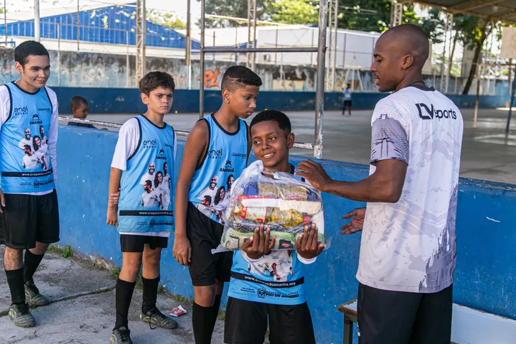 Alunos do projeto recebendo cesta básicas