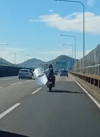 Um motociclista foi filmado pilotando, no sentido Niterói, com apenas uma das mãos