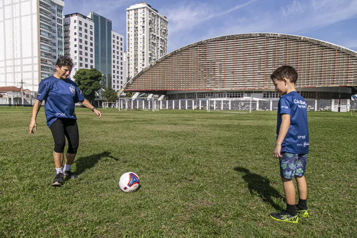Cenira e seu neto jogando bola no estádio Caio Martins, em Niterói
