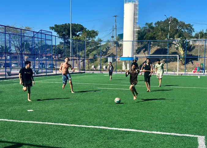 Crianças jogam futebol na quadra do parque