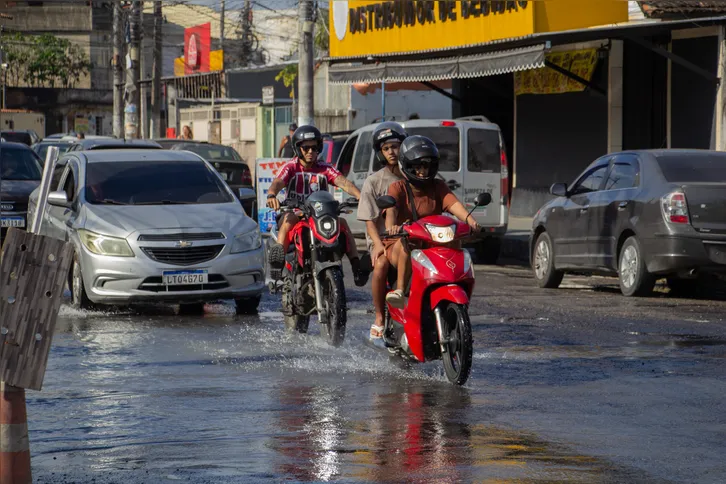 Motociclistas erguem as pernas ao passar pela água