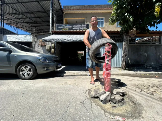 O morador trabalha em sua residência e vem sofrendo com os buracos em frente a porta de sua casa
