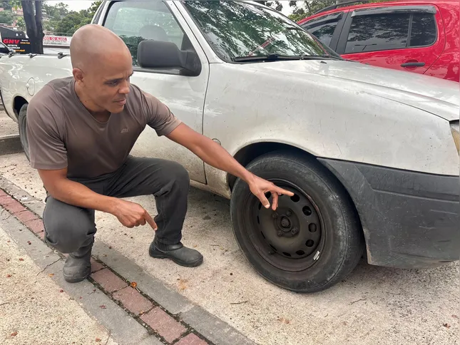 José Ricardo aponta pneu danificado em decorrência de um buraco na RJ-104