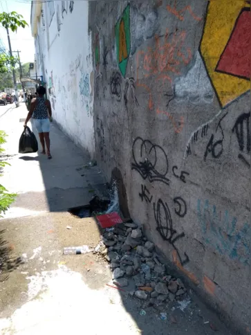 A água está criando um buraco no chão da calçada