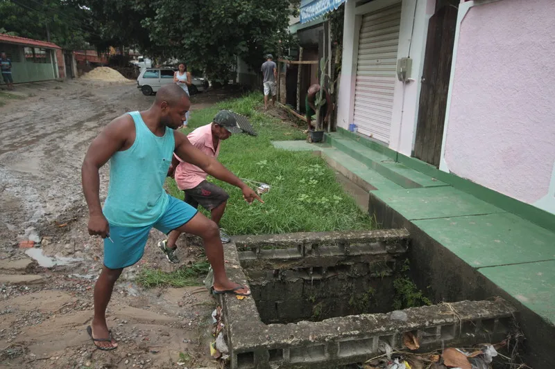 Moradores mostram situação do bueiro sem tampa e que está entupido na Rua Josefa Ferreira