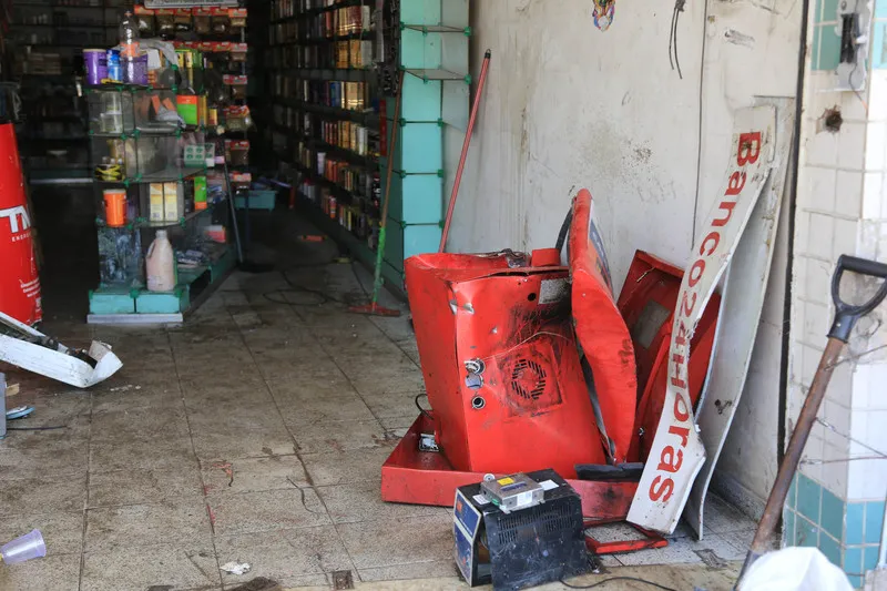Criminosos usaram uma retroescavadeira para arrombar a porta da farmácia e retirar o caixa eletrônico do estabelecimento comercial