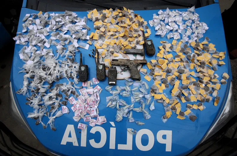Além dos rádios, arma, celular e drogas foram apreendidas.