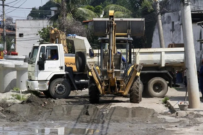 Homens e máquinas trabalham na finalização da estrada