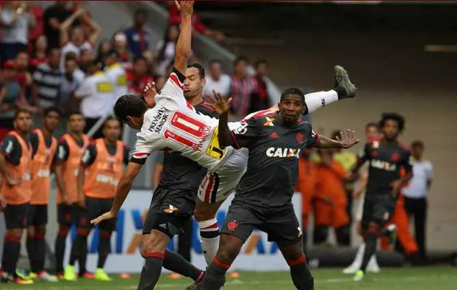 Em jogo muito equilibrado, Ganso disputa bola com Réver e Rodnei no empate de 2 a 2 no Estádio Mané Garrincha, em Brasília.

